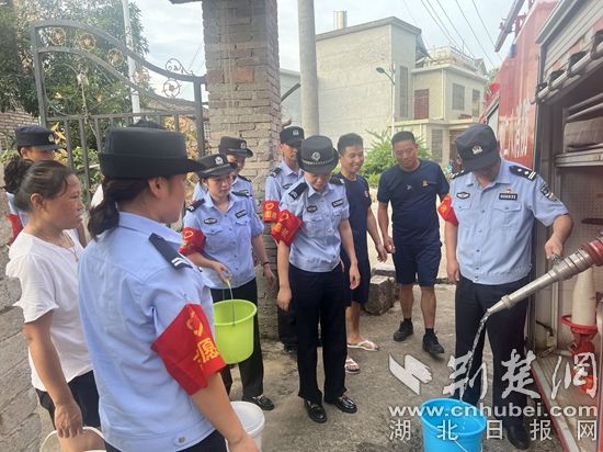 民輔警跟隨消防水車作業(yè)，通過肩挑手提的方式將清水送入行動不便的老年、殘障村民的家中（通訊員 李麗君 攝） (3).jpg.jpg