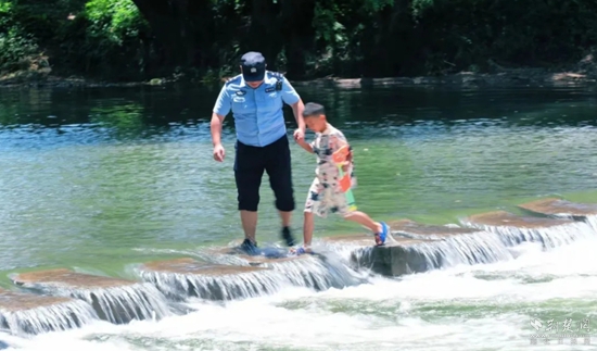 馬橋派出所民警牽著在河中玩水的孩子返回岸邊.jpg